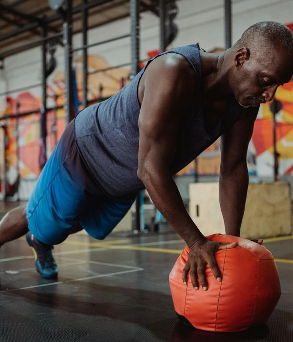 Man performing core strengthening exercises in a gym environment